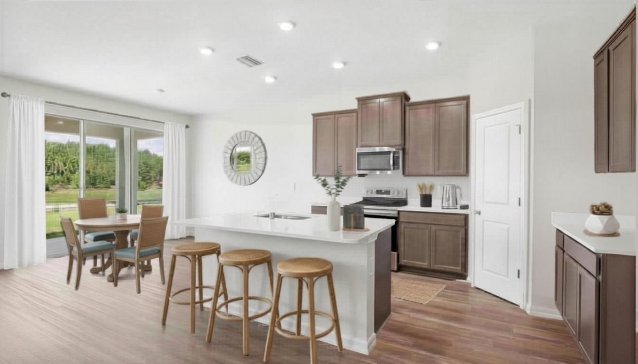 Kitchen with island seating, quartz counters, spacious pantry and stainless-steel appliances.