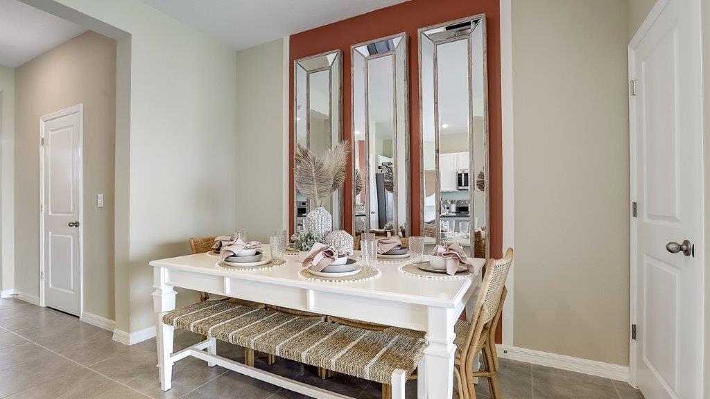 Dining room adjacent to the kitchen with table, chairs and tile flooring.