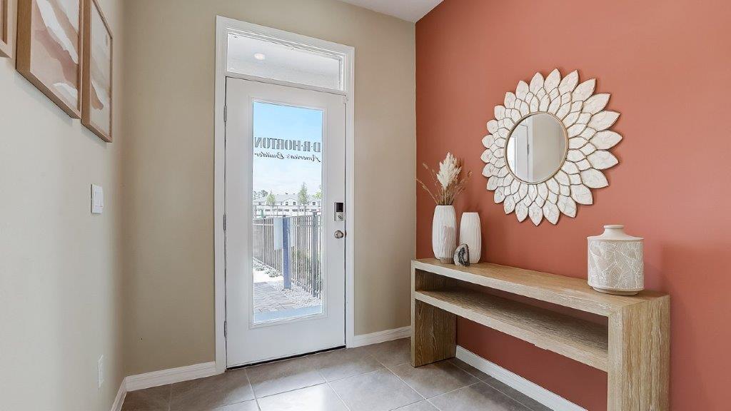 Home entry way thru the front door with tile flooring and a view to the living space.