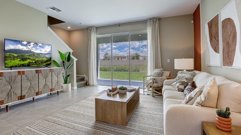 Open concept living area with couch seating and access to the backyard thru slider door.