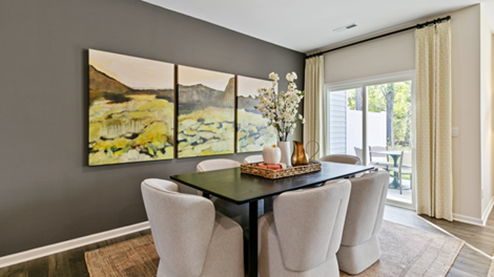 formal dining room featuring a table and green paintings