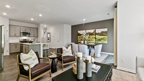 living room featuring beige sofa, 2 accent chairs and brown and green decor