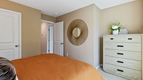 bedroom featuring a bed with orange bedding and neutral decor