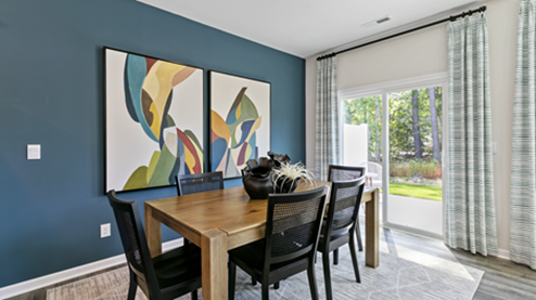 formal dining room featuring a teal accent wall and wooden table with chairs