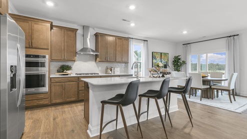 kitchen with quartz counters, kitchen island, pantry, stainless steel appliances
