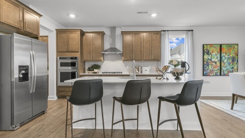 kitchen with quartz counters, kitchen island, pantry, stainless steel appliances
