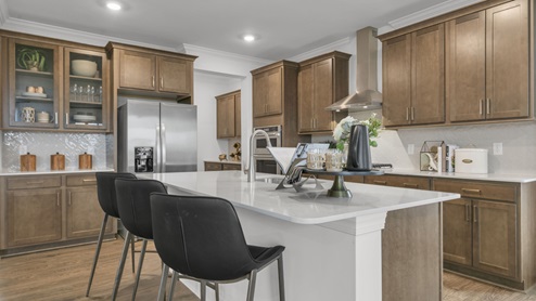 kitchen with quartz counters, kitchen island, pantry, stainless steel appliances