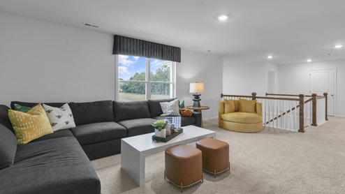 upstairs loft area with large windows and carpeting