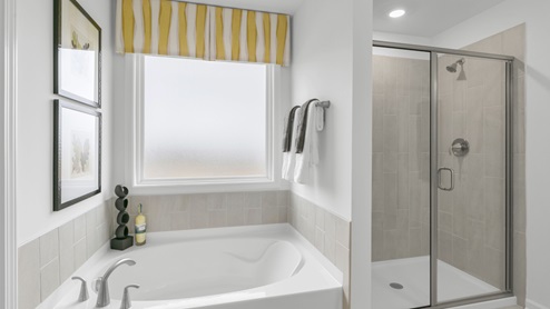 primary bathroom with walk in shower and dual vanity sinks