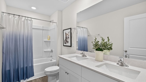 secondary bathroom with shower tub combo and double vanity sink