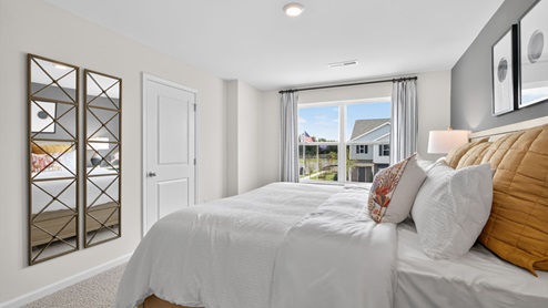 primary bedroom with two windows and carpeting, attached bath