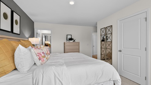 primary bedroom with two windows and carpeting, attached bath