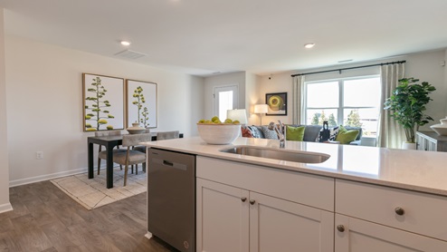 kitchen with quartz counters, kitchen island, pantry, stainless steel appliances