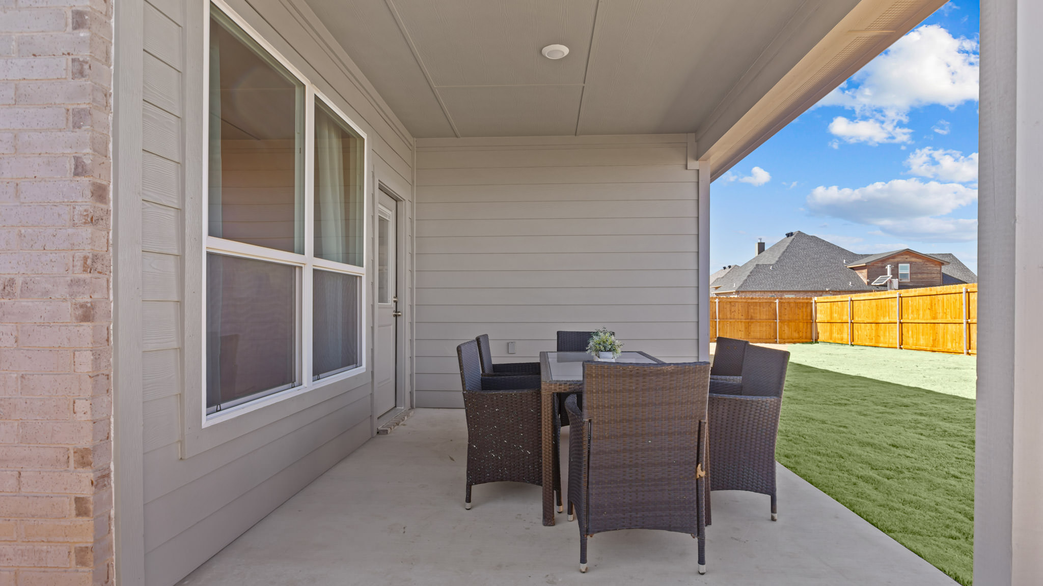 Covered back patio area overlooking spacious backyard
