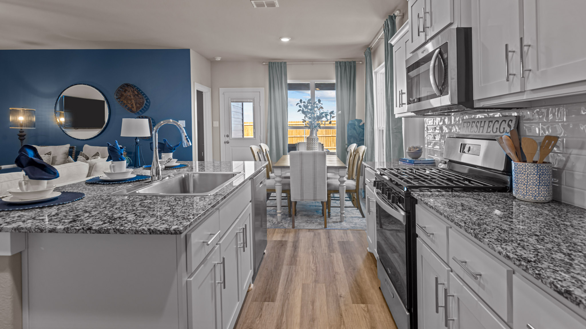 Open concept kitchen with stainless steel appliances, shaker style cabinets, and elevated finishes