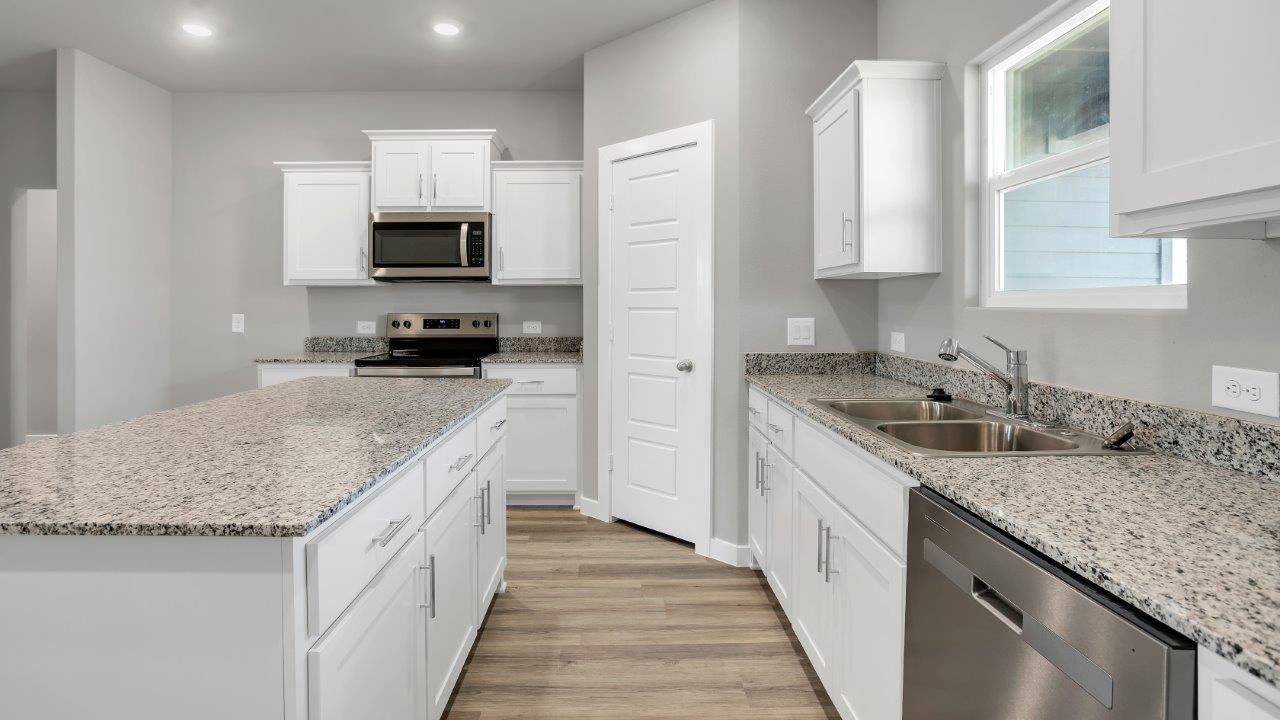 Open concept kitchen with stainless steel appliances, shaker style cabinets, and elevated finishes