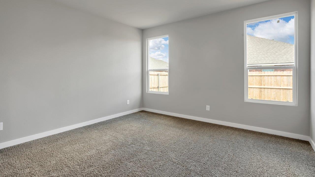 Primary bedroom with plush carpet floors and light allowing double windows