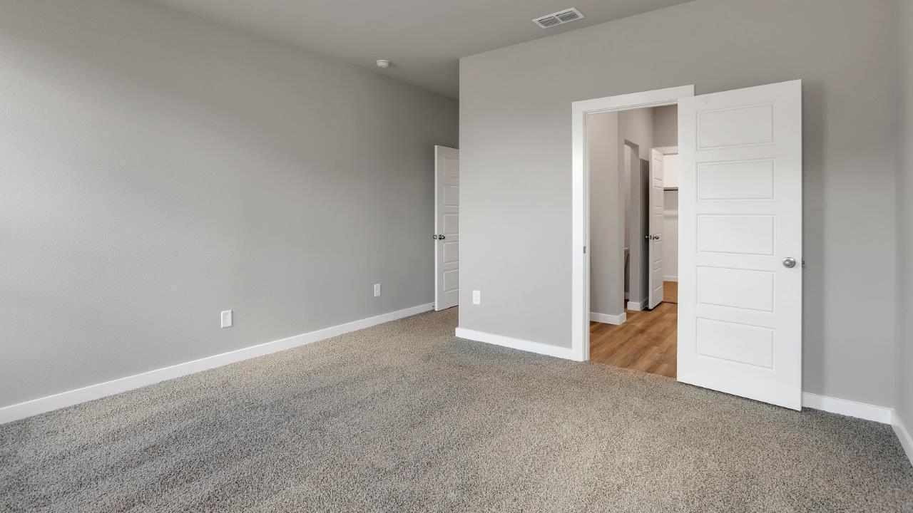 Primary bedroom with private attached bathroom and walk-in closet
