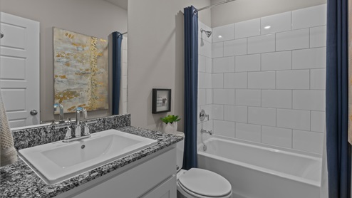 Guest bathroom with blue accent colors and built in vanity