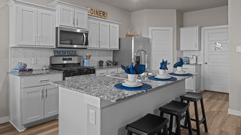 Open kitchen, living, and dining space with spacious kitchen island and meal prep space