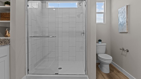 Primary bathroom with tiled walk-in closet and separate toilet space