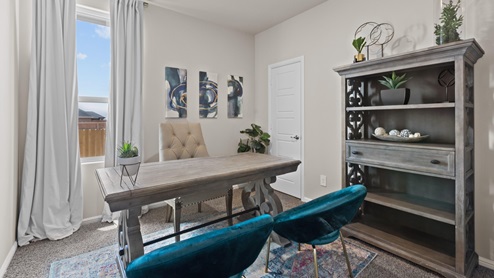 Interior guest bedroom designed as an office space with dark blue accents