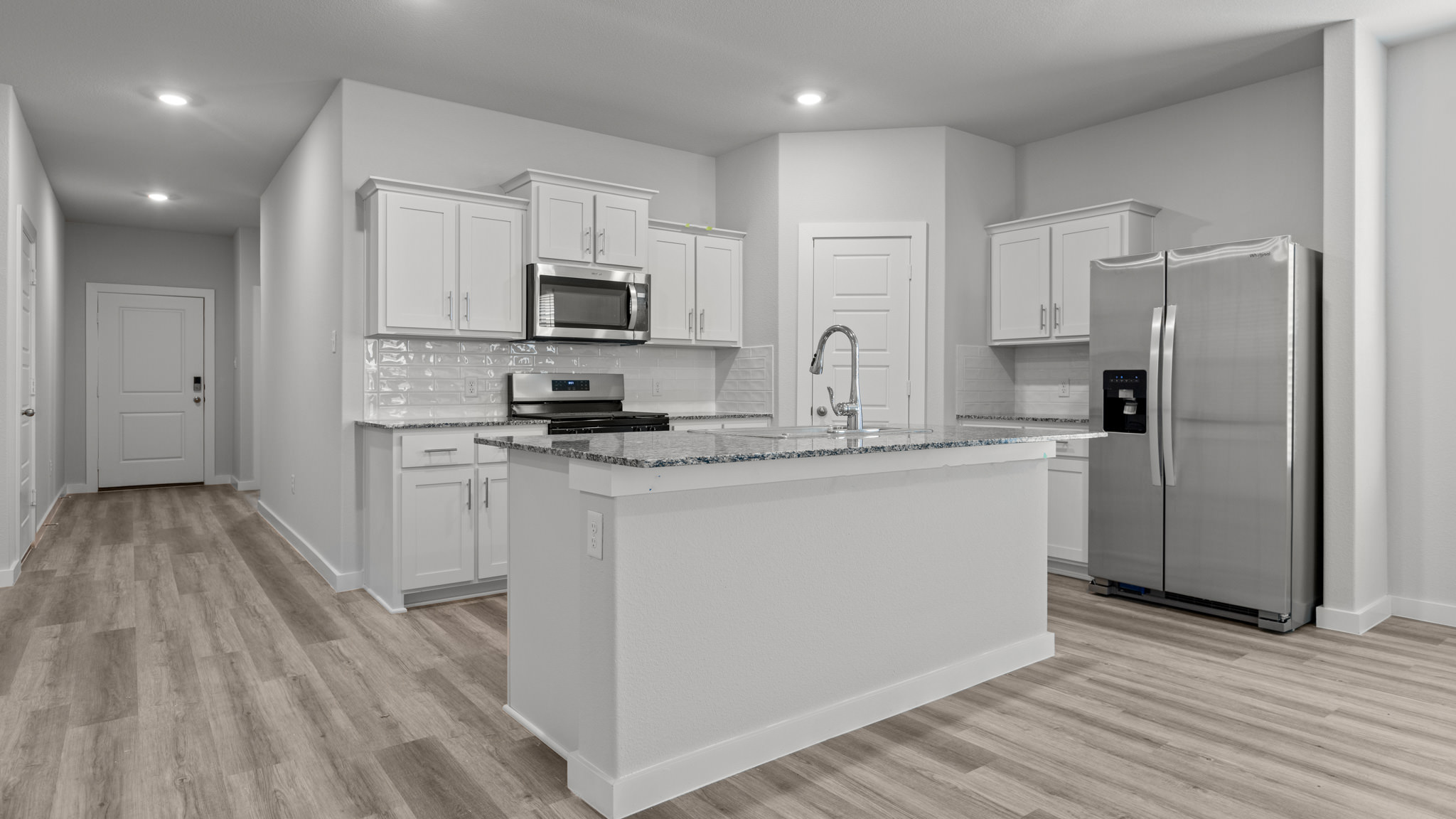 Open concept kitchen with stainless steel appliances, shaker style cabinets, and elevated finishes