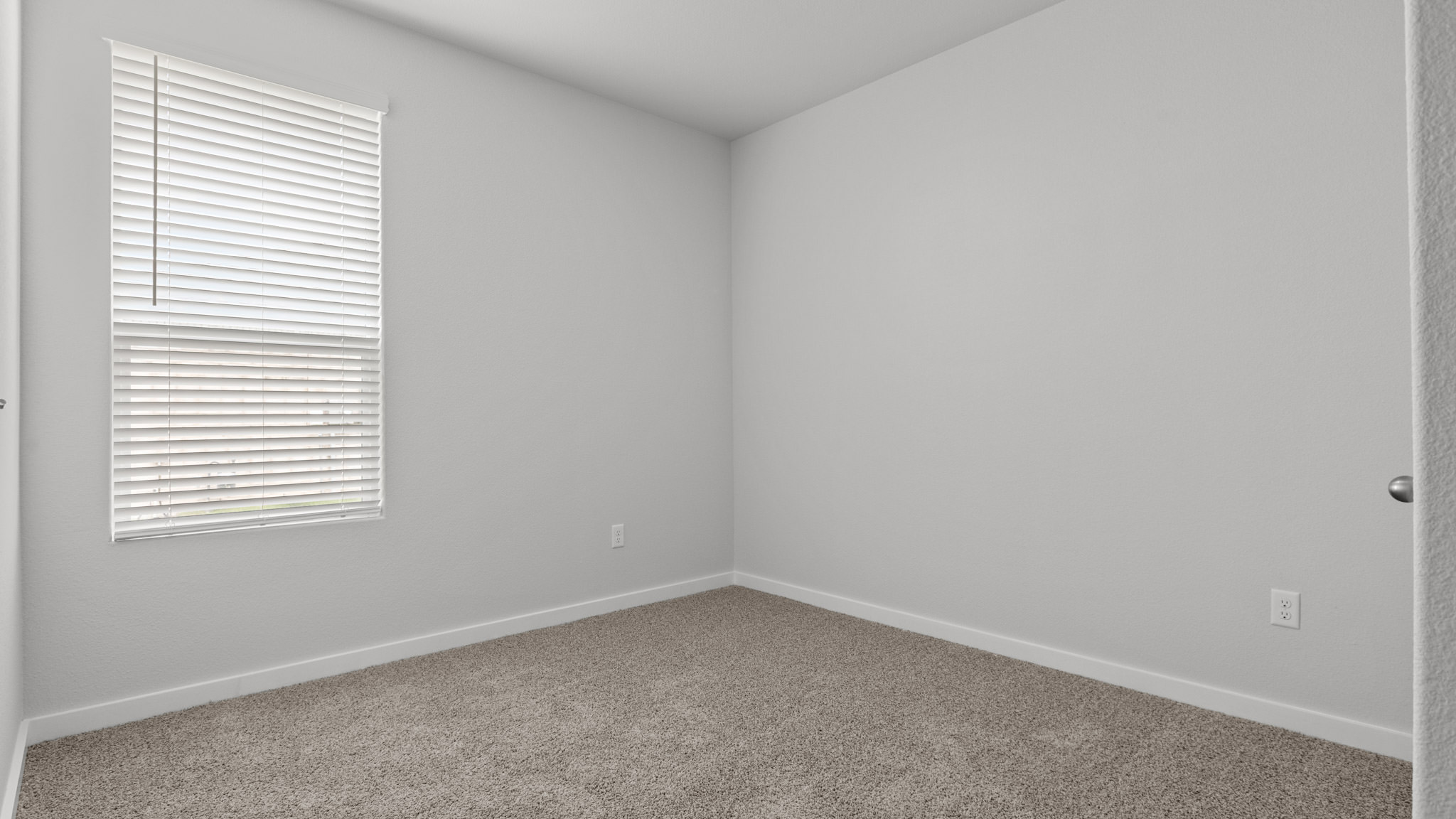 Guest bedroom 2 with side window and plush carpet floor