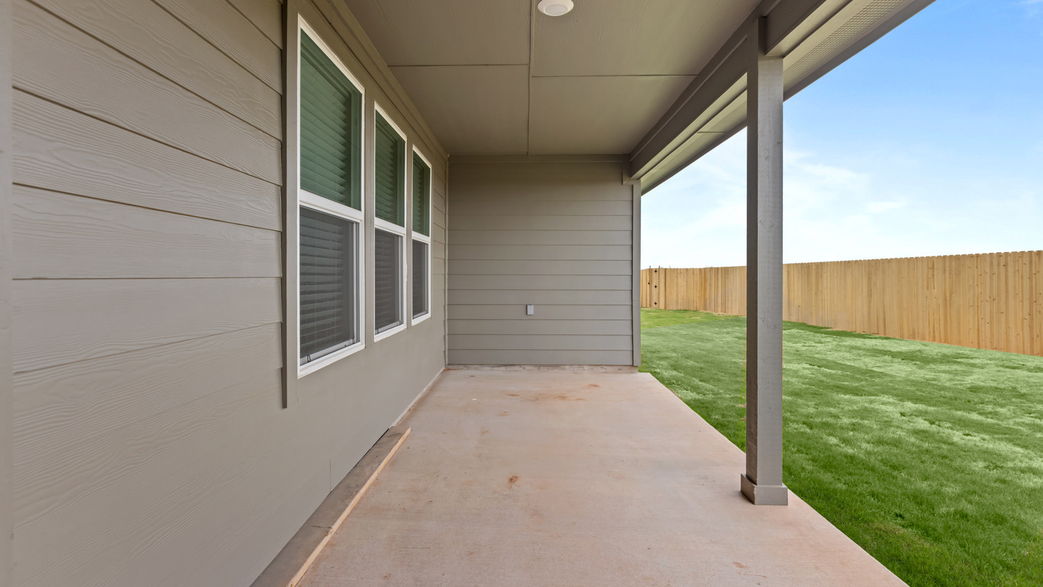 Covered back patio area overlooking spacious backyard