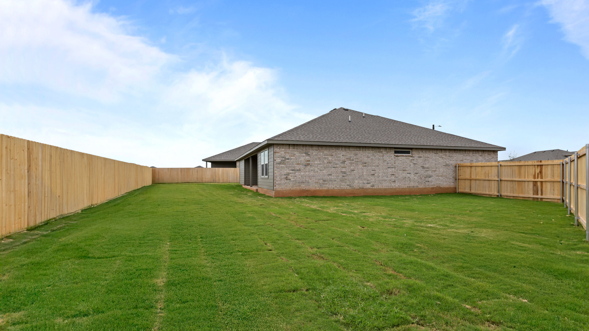 Overview of spacious private fenced-in backyard