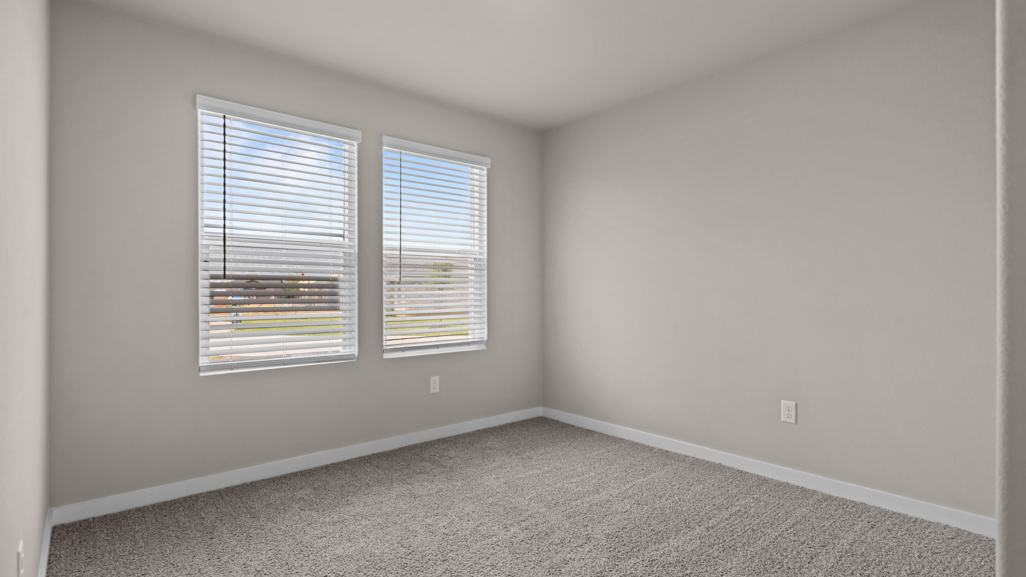 Guest bedroom 2 with side window and plush carpet floor