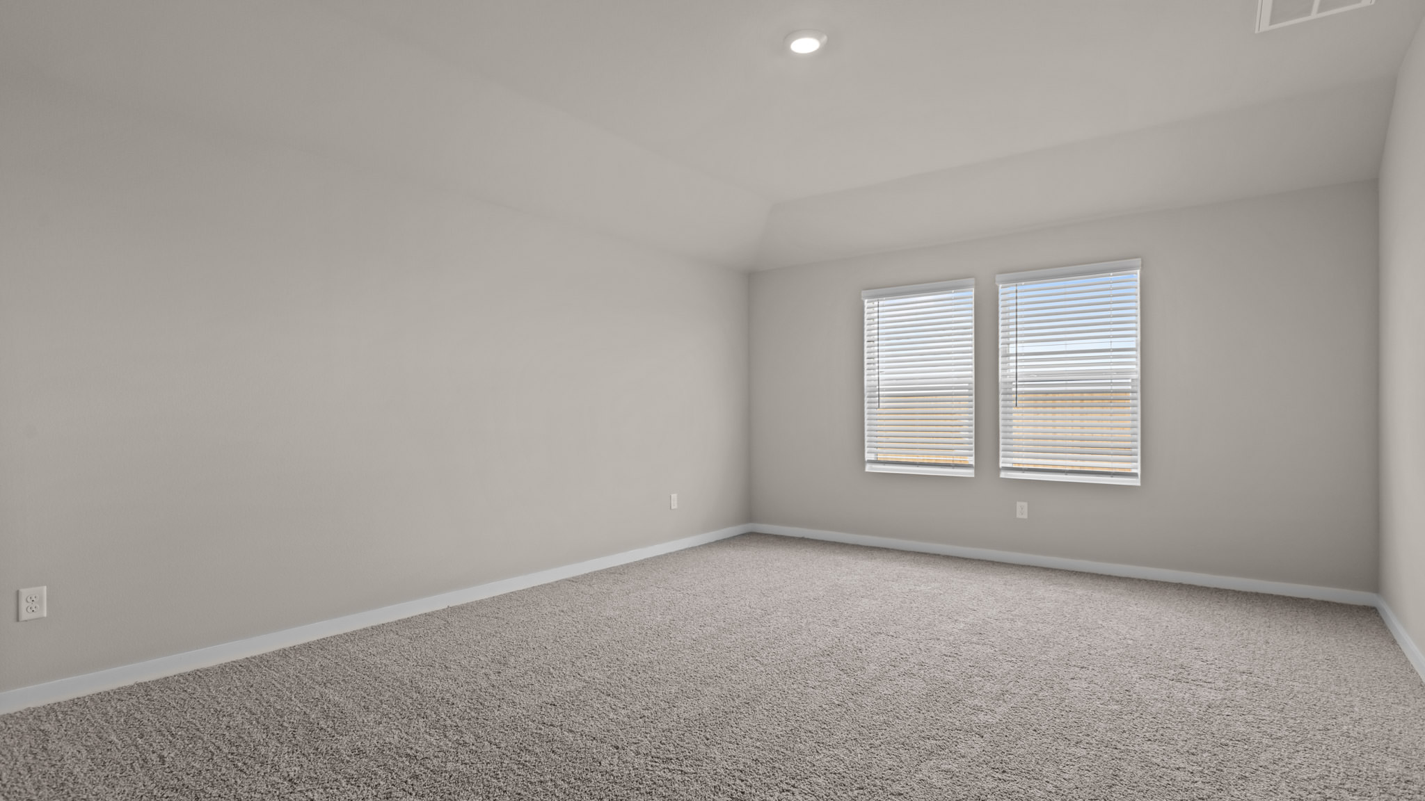 Primary bedroom with plush carpet floors and light allowing double windows