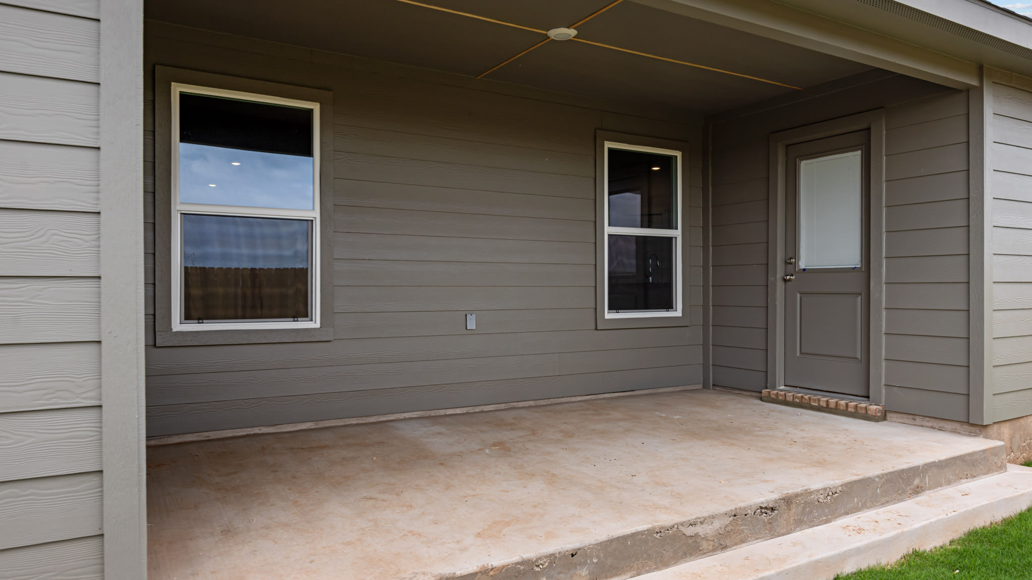 Covered back patio area overlooking spacious backyard
