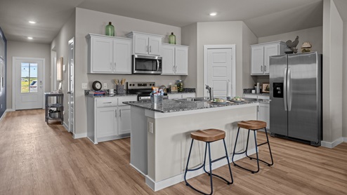 Open concept kitchen with stainless steel appliances, shaker style cabinets, and elevated finishes