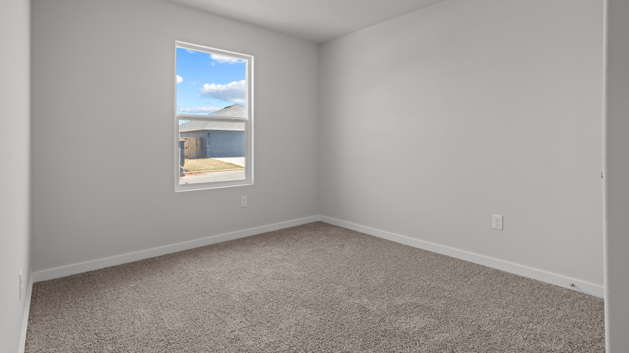 Guest bedroom 1 with side window and plush carpet floor