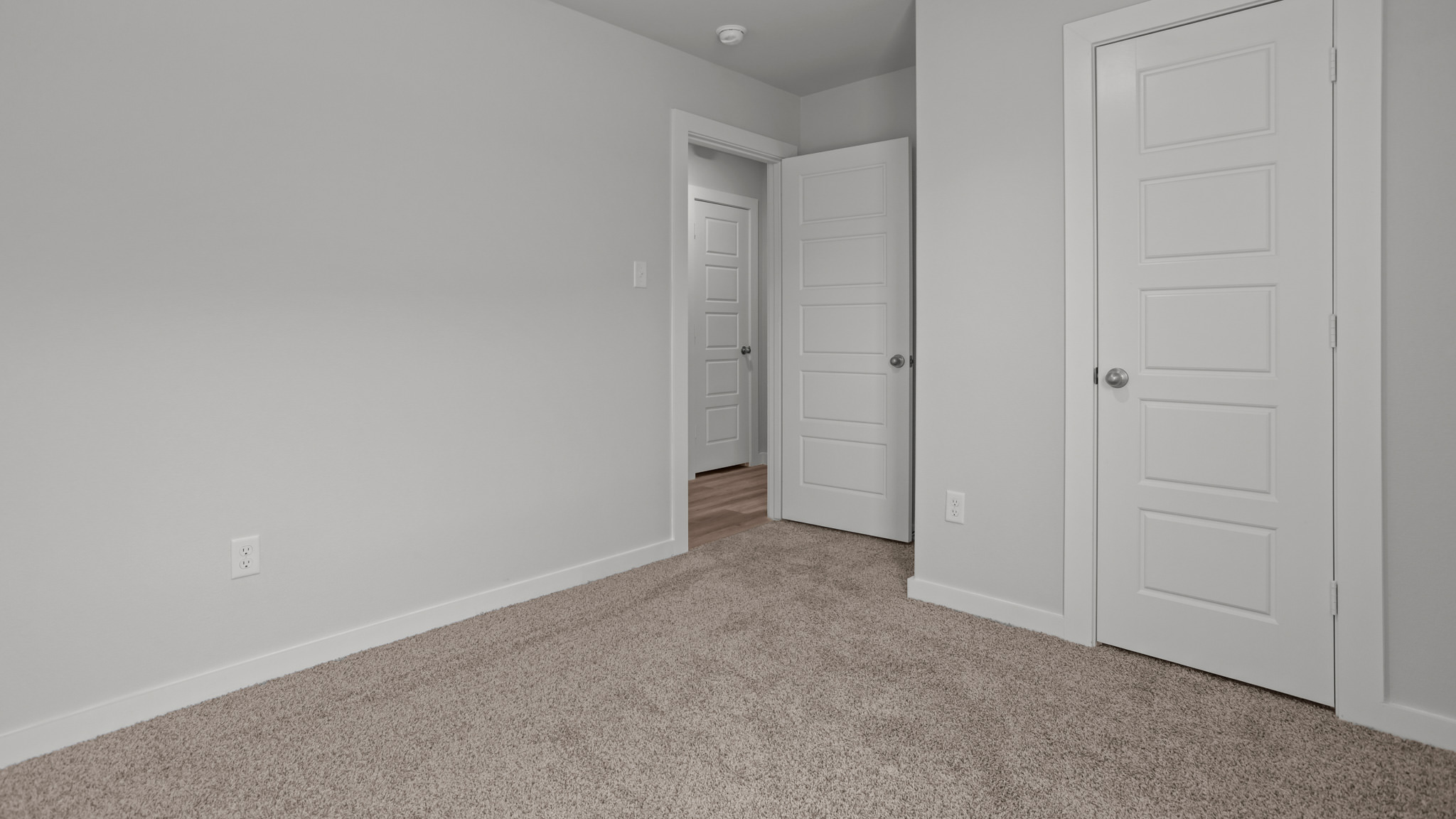 Guest bedroom 2 with side window and plush carpet floor