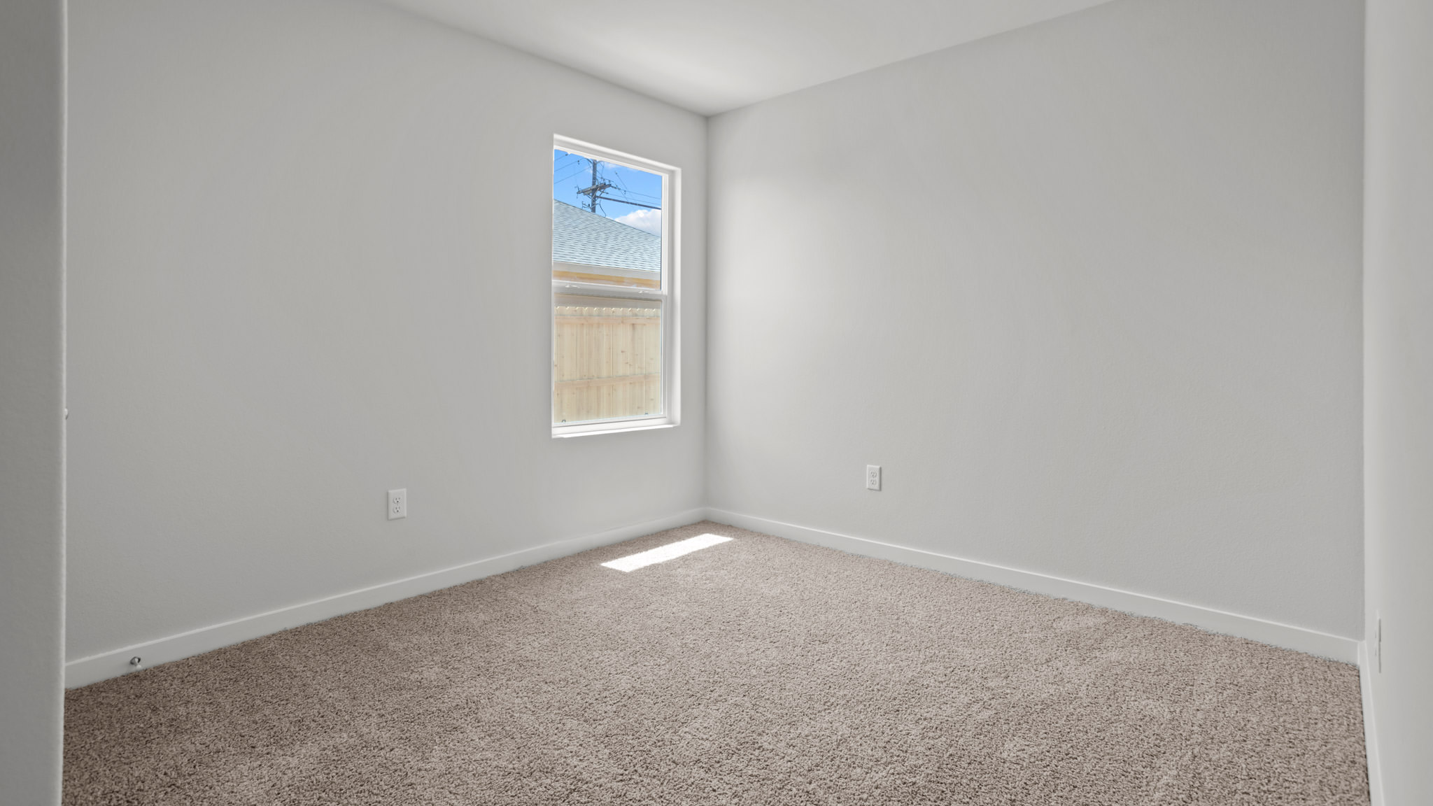 Guest bedroom 2 with side window and plush carpet floor