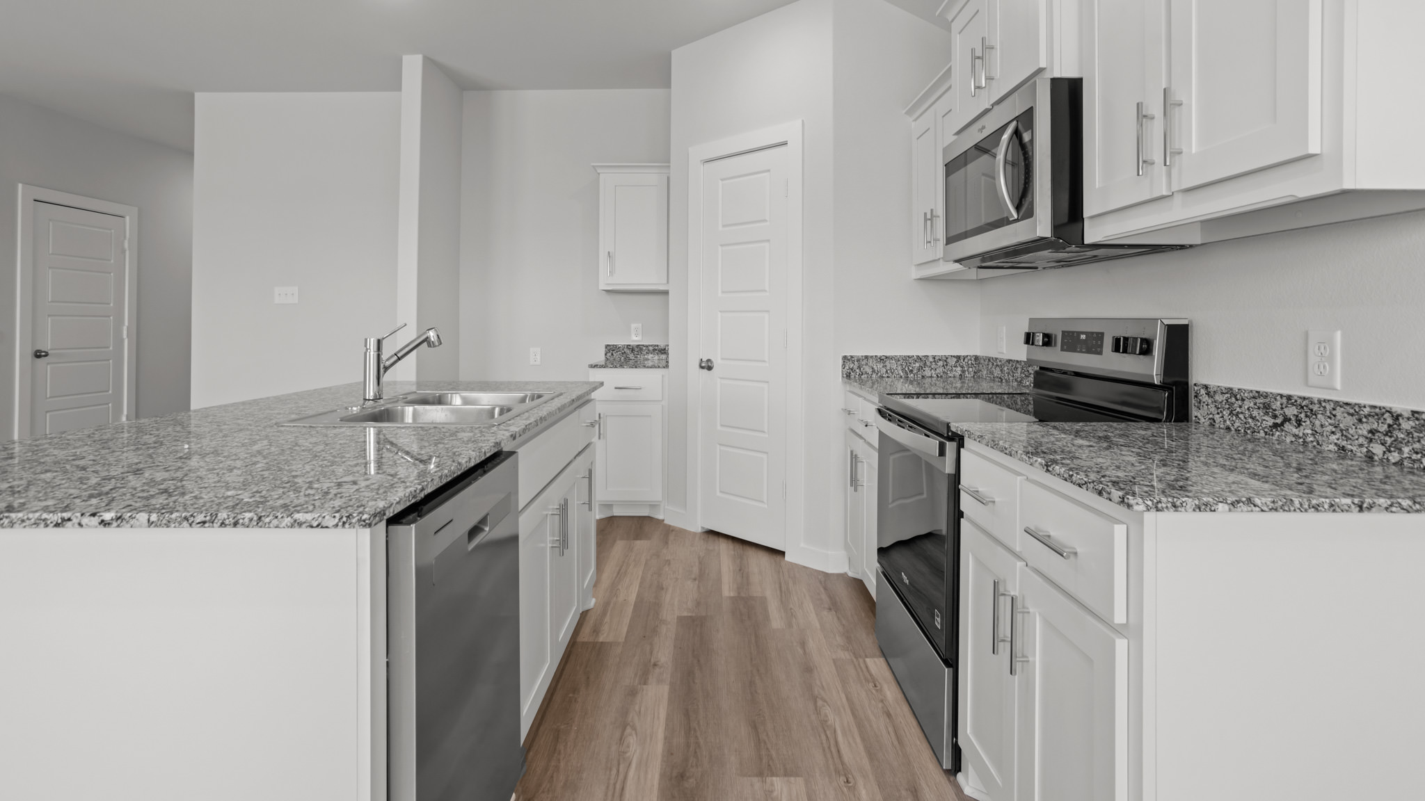 Open concept kitchen with stainless steel appliances, shaker style cabinets, and elevated finishes
