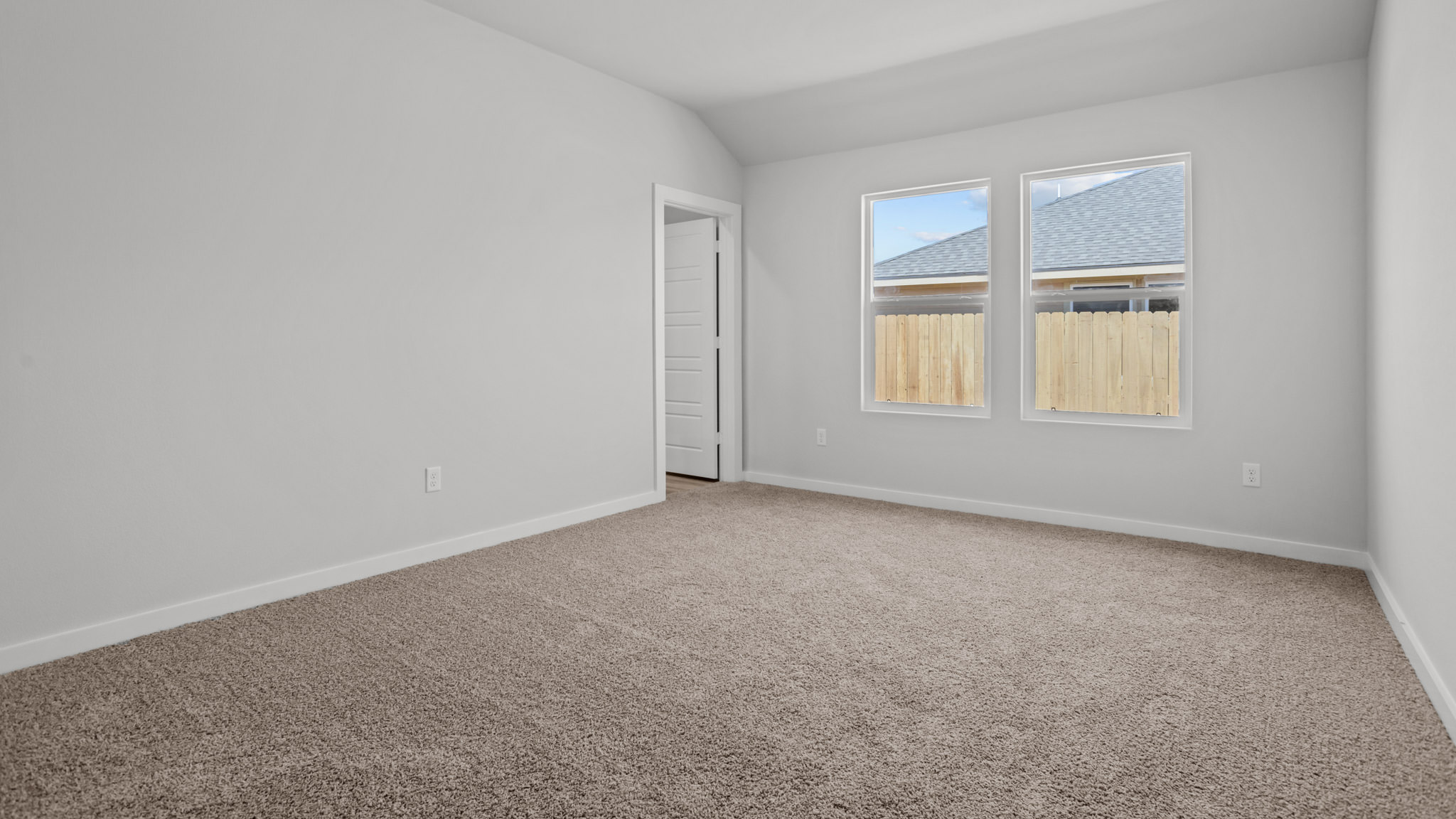 Primary bedroom with plush carpet floors and light allowing double windows