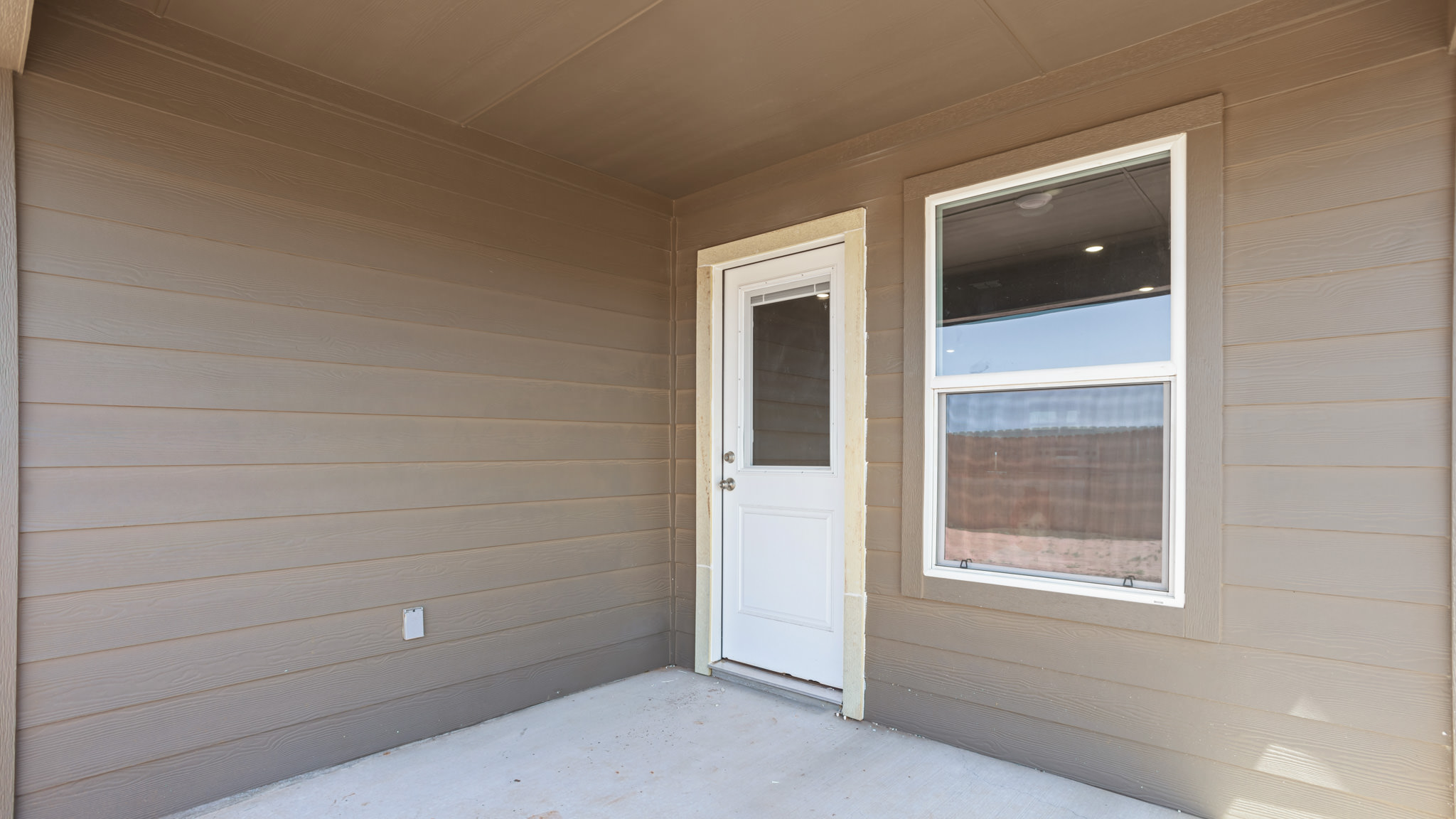 Covered back patio area overlooking spacious backyard