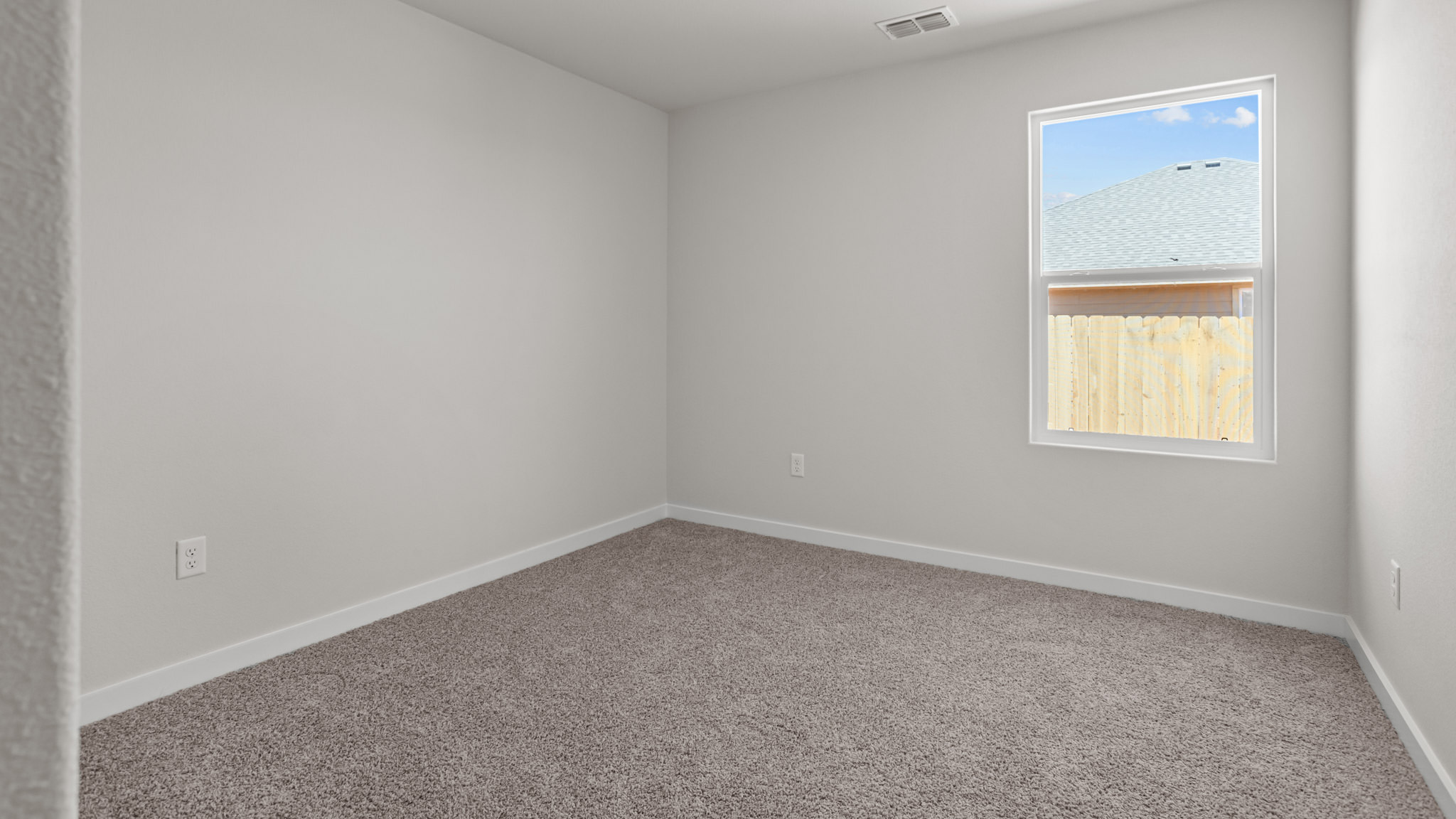 Guest bedroom 2 with side window and plush carpet floor