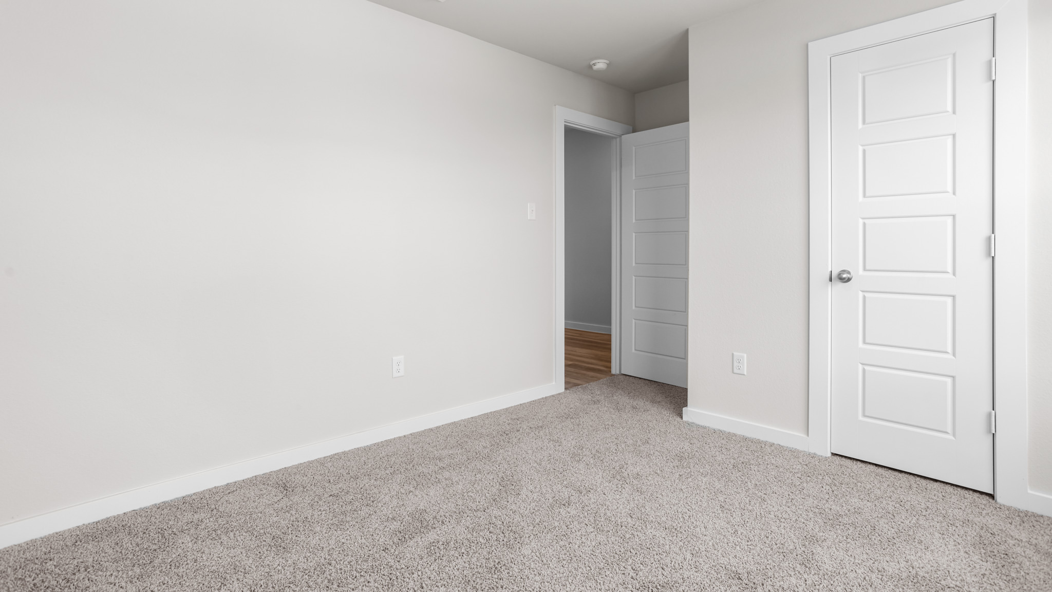 Guest bedroom 2 with side window and plush carpet floor