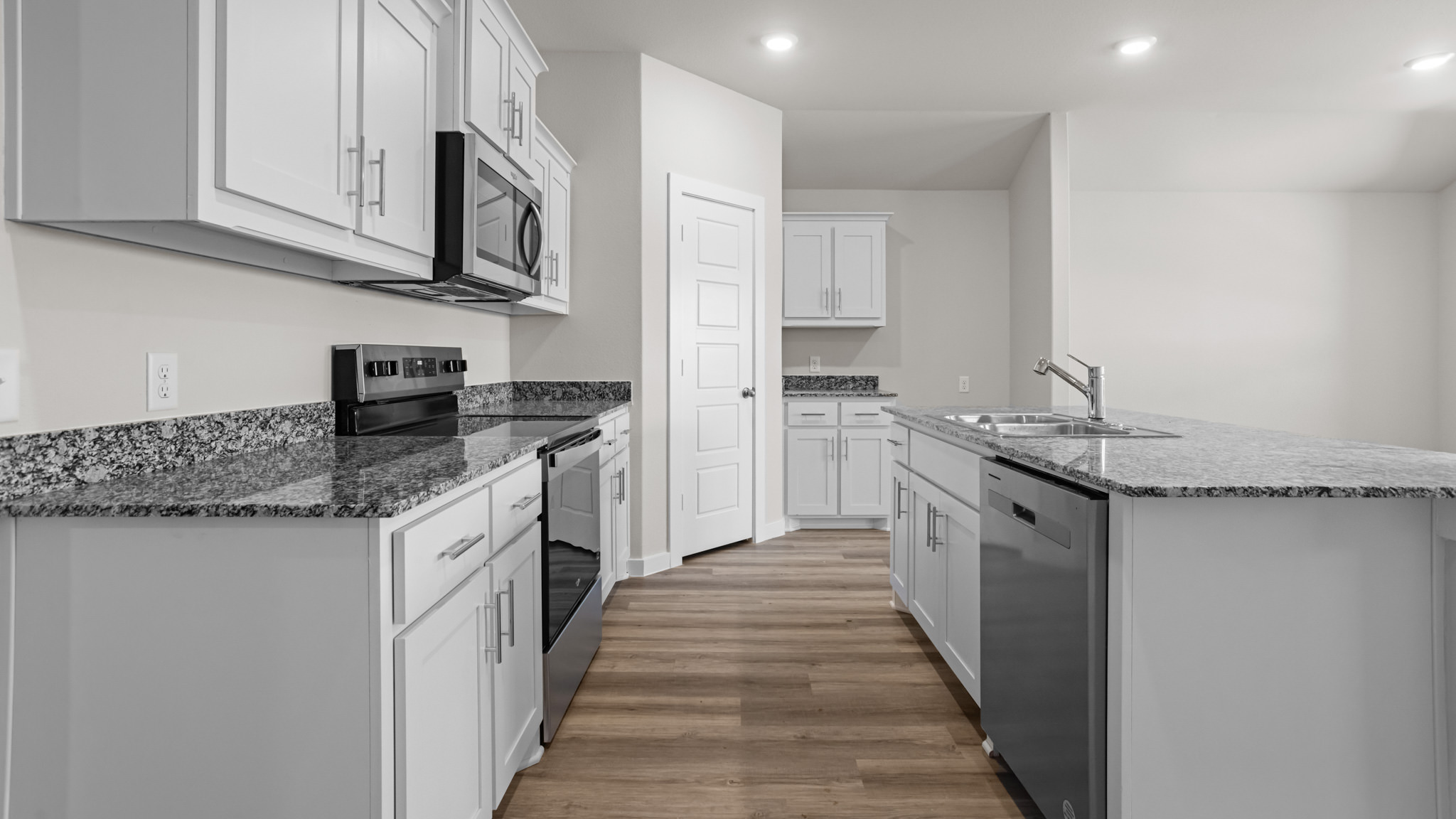 Open concept kitchen with stainless steel appliances, shaker style cabinets, and elevated finishes