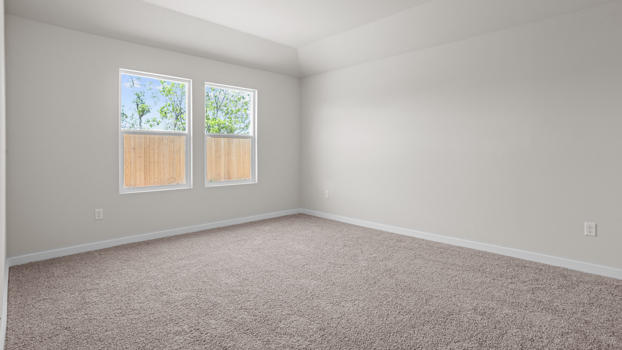 Primary bedroom with plush carpet floors and light allowing double windows