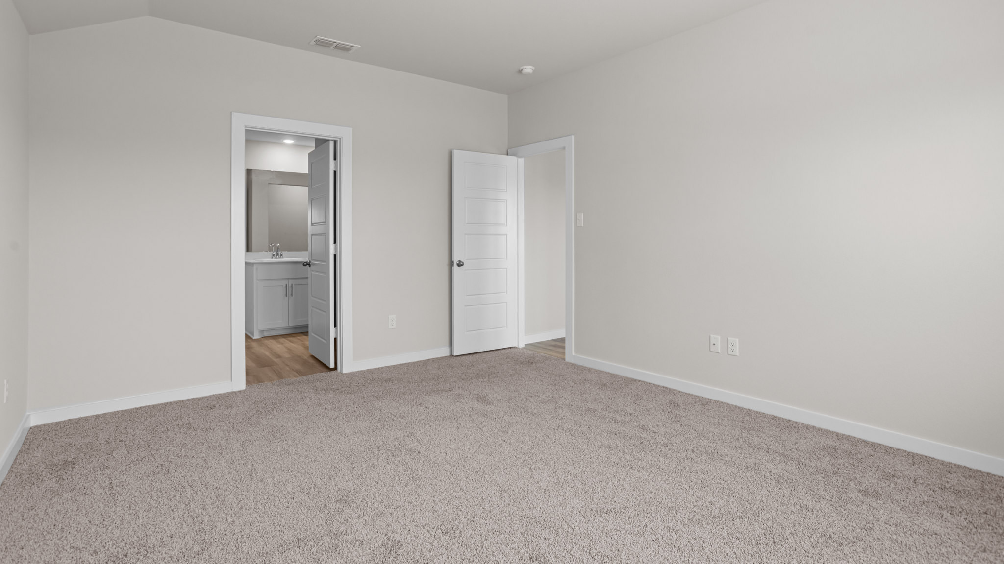 Primary bedroom with private attached bathroom and walk-in closet