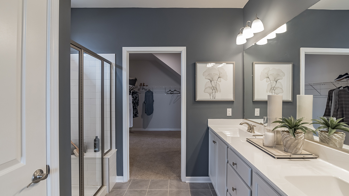 The bathroom connected to the primary bedroom includes a toilet shower only closet and a double bowl vanity with storage below.
