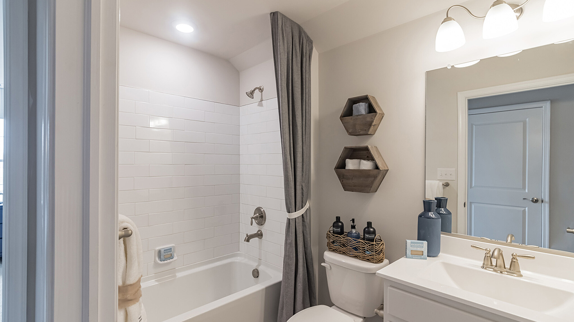 The third bathroom includes single white vanity and bathtub.
