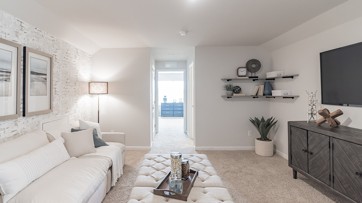 Different view of the loft area upstairs with views of a bedroom in the back.