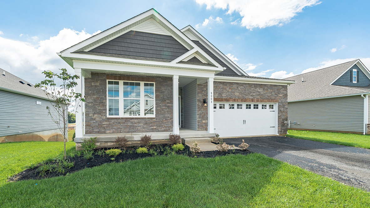 A photo of a Clifton home with stone siding and shake style navy blue accent siding, white trim, and white two car garage.