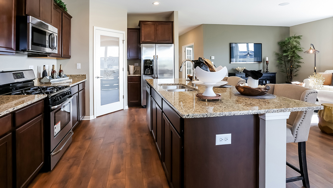 The kitchen flows perfectly into the sizeable living room. Spacious open concept kitchen, island, and living room. Kitchen with large island with stainless steel appliances.